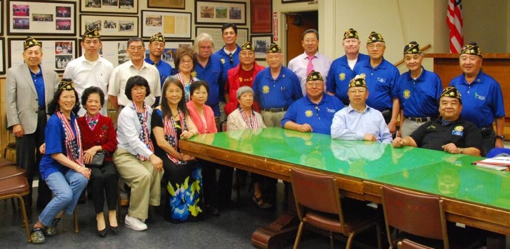 Post 628 veterans, family members, and friends gathered around a meeting table.